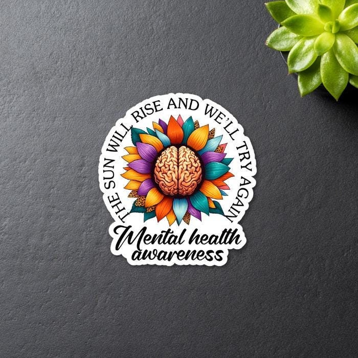Mental Health Awareness Floral Brain Sticker - with quote The Sun Will Rise and We'll Try Again. Black background, front view, close up.